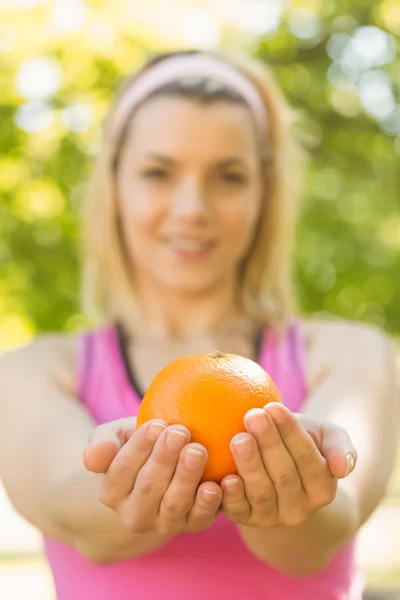 Ταιριάζει ξανθιά κρατώντας ένα πορτοκάλι — Φωτογραφία Αρχείου