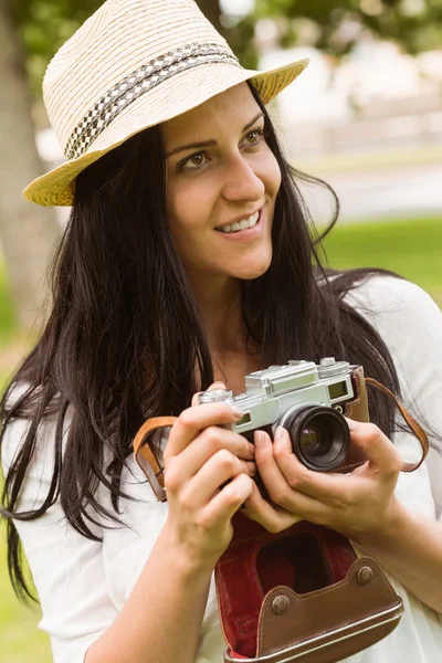 Morena feliz em chapéu de palha segurando câmera retro — Fotografia de Stock