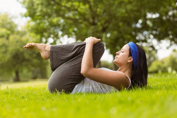 Innehåll brunett gör yoga på gräs — Stockfoto