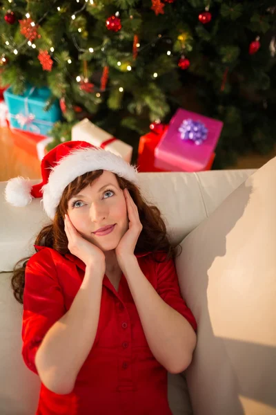 Cabello rojo en sombrero de santa relajarse en el sofá en Navidad —  Fotos de Stock