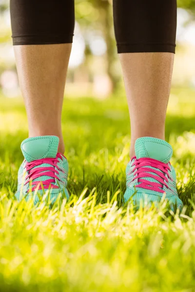 Woman in running shoes standing on grass — Stock Photo, Image