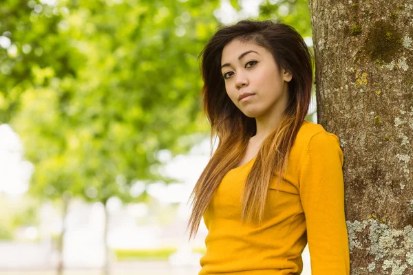 Woman standing against tree — Stock Photo, Image