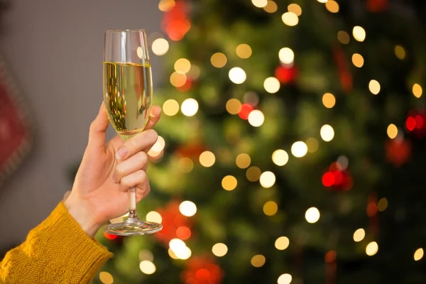 Rossa che tiene un bicchiere di champagne sul divano a Natale — Foto Stock