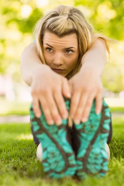 Passa blond stretching på gräset — Stockfoto