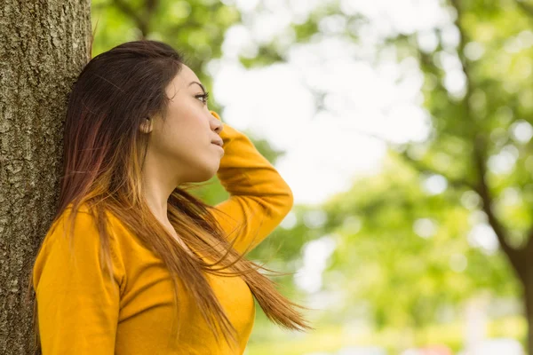 Frau steht gegen Baum — Stockfoto