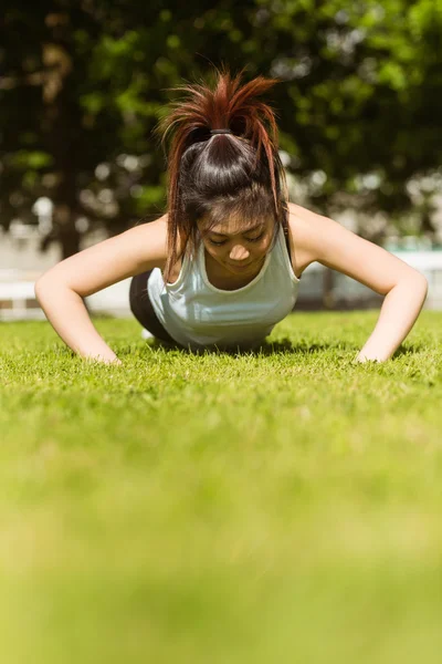 Frau macht Liegestütze im Park — Stockfoto