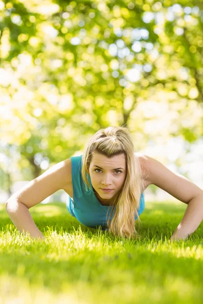Encaixe loira fazendo flexões no parque — Fotografia de Stock