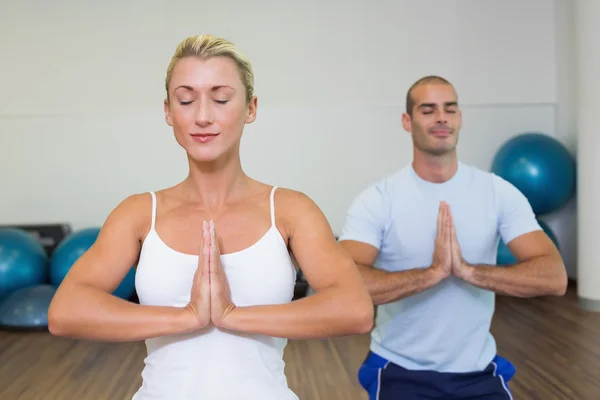 Casal com mãos e olhos unidos fechados no estúdio de fitness — Fotografia de Stock