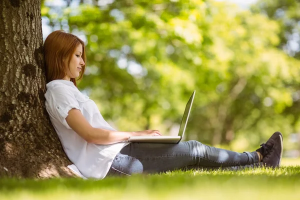 Bella rossa seduta con il suo computer portatile — Foto Stock