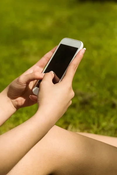 Hands holding smartphone in park — Stock Photo, Image