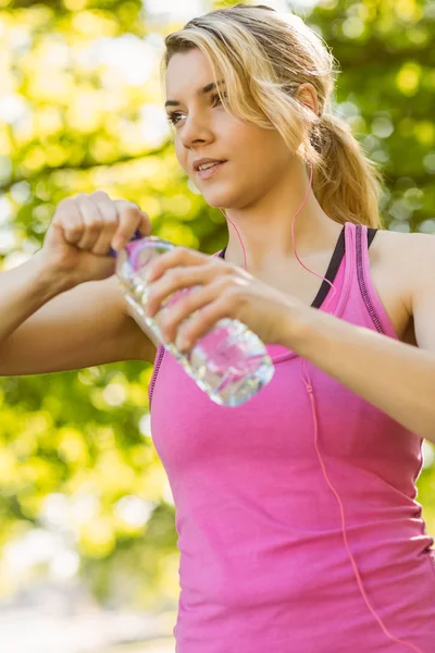 Fit blonde haar fles water houden — Stockfoto