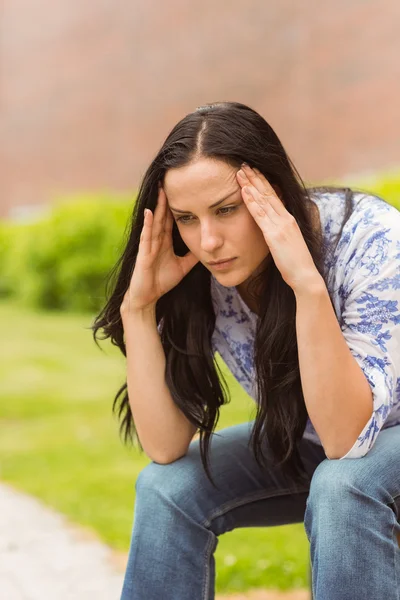 Lässige Brünette leidet unter Kopfschmerzen — Stockfoto