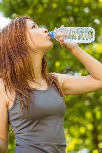 Pretty redhead drinking water in park — Stock Photo, Image