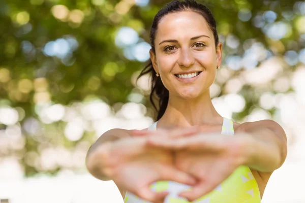 Happy passar brunett stretching i parken — Stockfoto