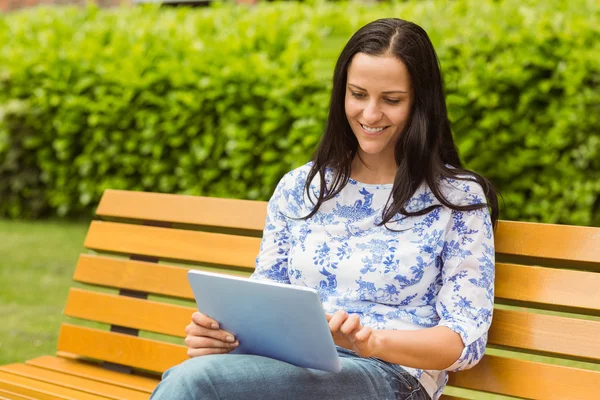 Felice bruna seduta su panca utilizzando tablet — Foto Stock