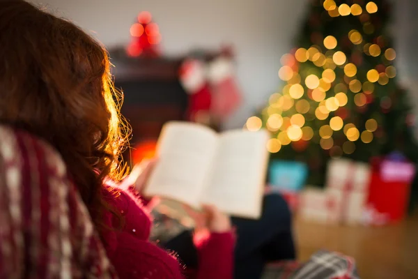 Rear view of redhead reading at christmas — Stock Photo, Image