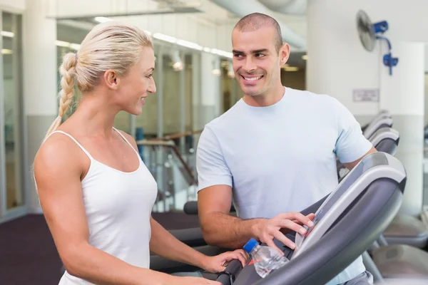 Trainer assisting woman with treadmill screen options at gym — Stock Photo, Image