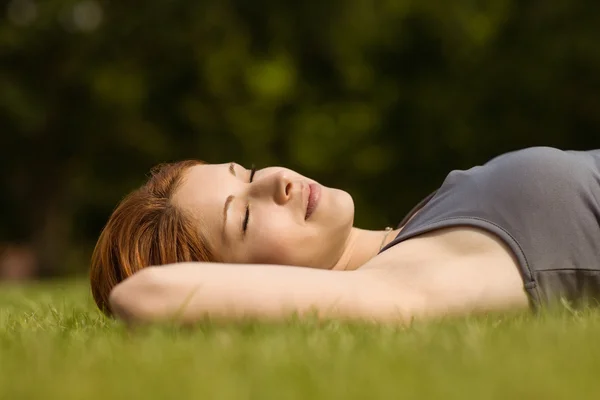 Pretty redhead lying with her eyes closed — Stock Photo, Image