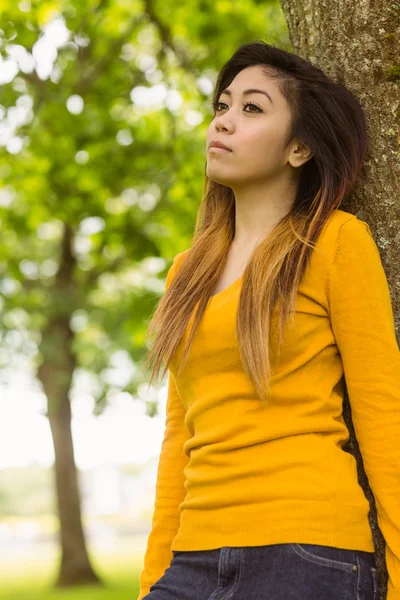 Donna in piedi contro l'albero — Foto Stock