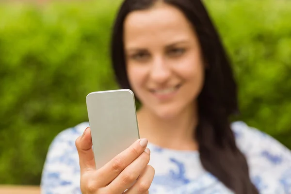 Morena sorridente usando seu telefone celular — Fotografia de Stock