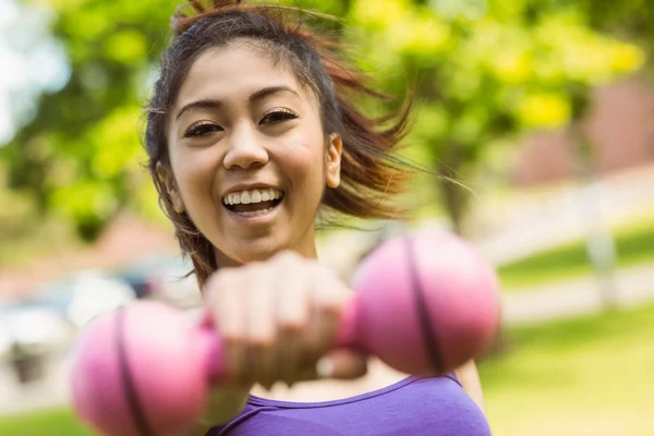 Woman lifting dumbbell in park — Stock Photo, Image