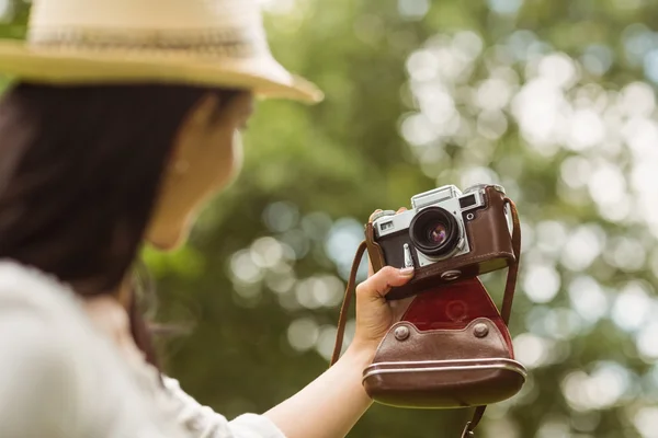 Brunette in straw hat taking a selfie with retro camera — Stock Photo, Image
