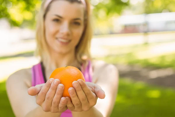 Ajuste rubia sosteniendo una naranja —  Fotos de Stock