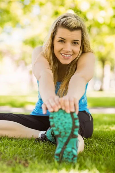 Fitte Blondine dehnt sich auf dem Gras — Stockfoto