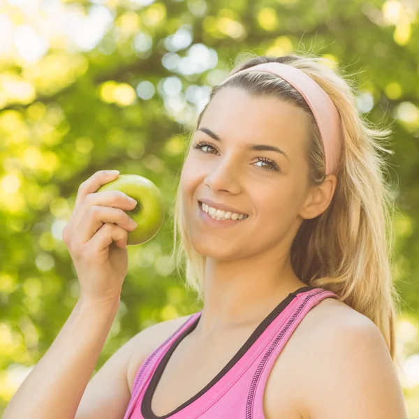 Fit blonde bedrijf groene appel — Stockfoto