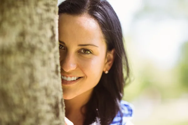 Portret van een mooie brunette leunend tegen een boom — Stockfoto