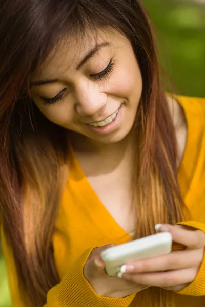 Woman text messaging in park — Stock Photo, Image