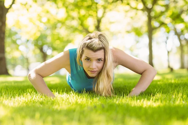 Přizpůsobit blondýnka dělá push up v parku — Stock fotografie