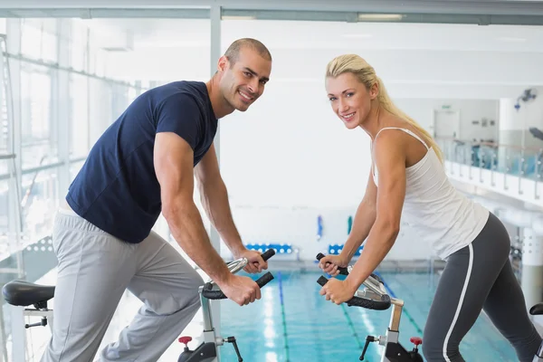 Casal trabalhando em bicicletas de exercício — Fotografia de Stock