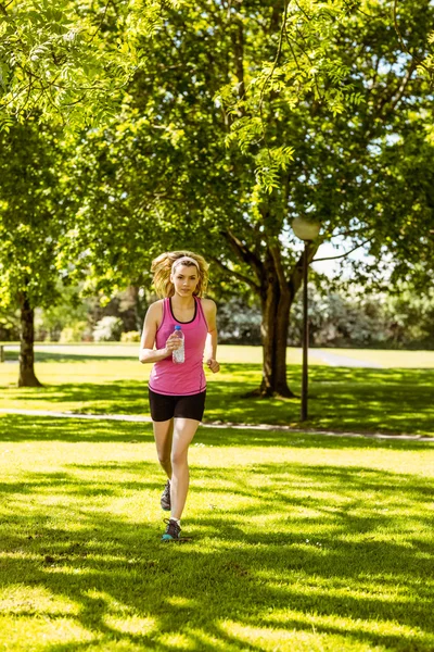 Fitte Blondine joggt im Park — Stockfoto
