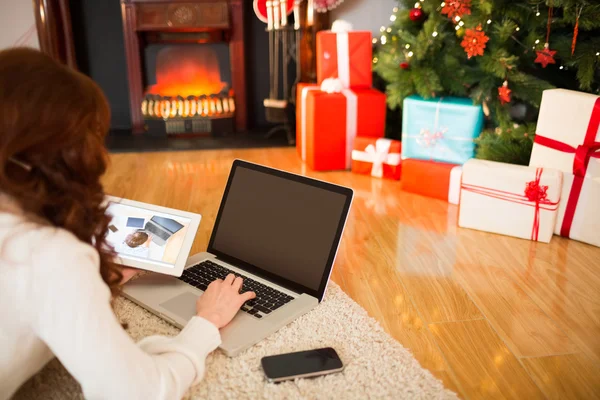 Ładna kobieta, leżąc na podłodze przy użyciu technologii w Chritmas — Zdjęcie stockowe