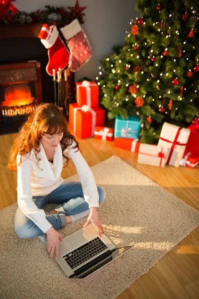 Donna rossa seduta sul pavimento utilizzando il computer portatile a Natale — Foto Stock