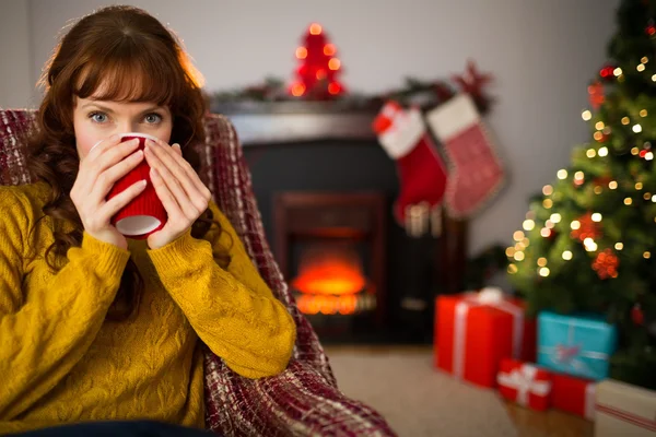 Cheerful redhead drinking hot drink at christmas — Stock Photo, Image