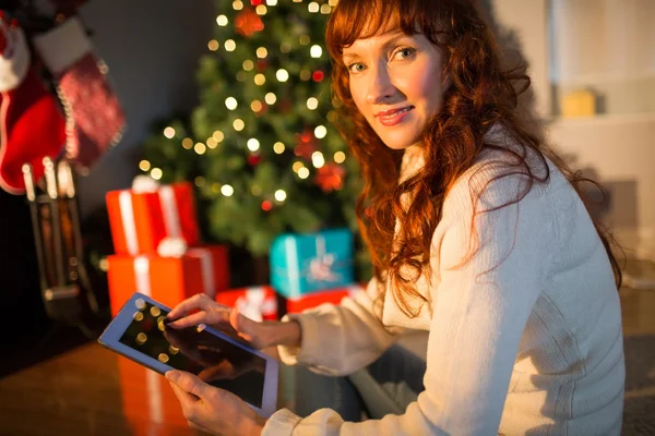 Donna rossa seduta sul pavimento utilizzando tablet a Natale — Foto Stock