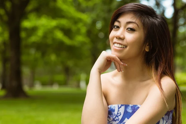 Woman with hand on chin in park — Stock Photo, Image