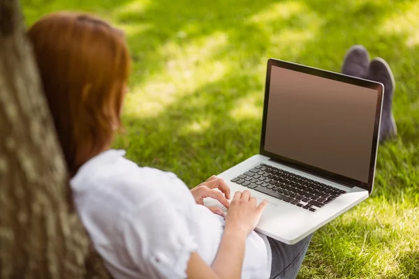 Mooie roodharige zit met haar laptop — Stockfoto