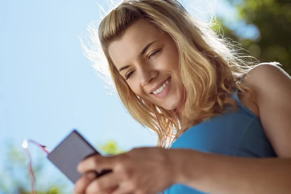 Passar blond textning på sin smartphone — Stockfoto