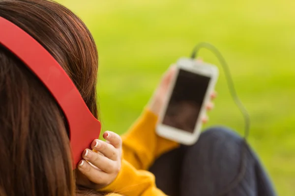 Femme appréciant la musique dans le parc — Photo