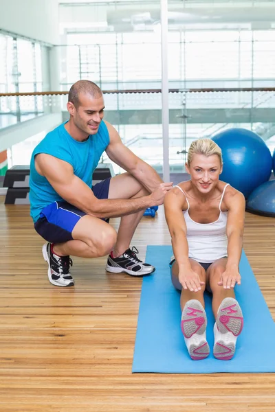 Treinador assistindo mulher com exercícios no estúdio de fitness — Fotografia de Stock