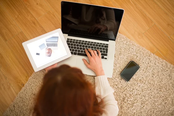 Pretty woman lying on floor using technology at Chritmas — Stock Photo, Image