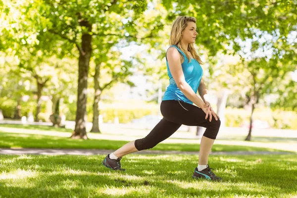 Passa blond stretching på gräset — Stockfoto