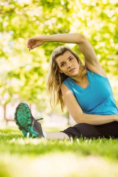 Přizpůsobit blond táhnoucí se v parku — Stock fotografie