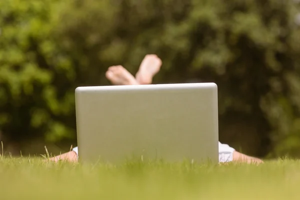 Söt rödhårig liggande med sin laptop — Stockfoto