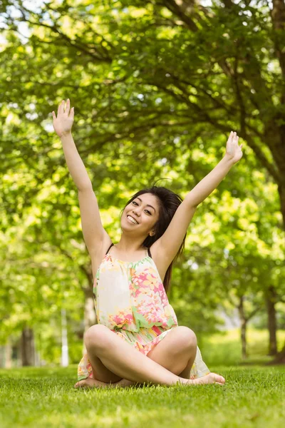 Jeune femme détendue assise au parc — Photo