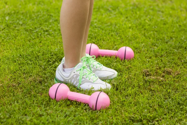 Woman with dumbbells on grass — Stock Photo, Image