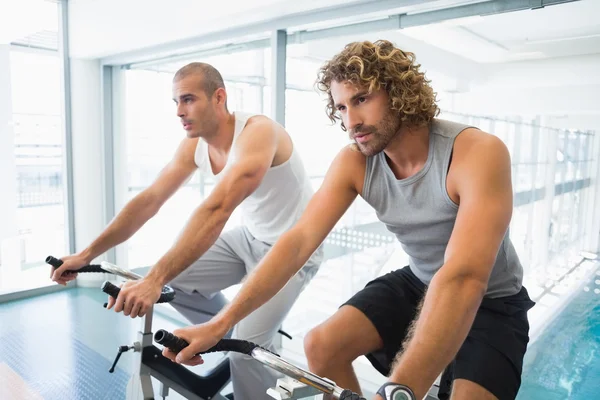 Uomini che lavorano sulle cyclette in palestra — Foto Stock